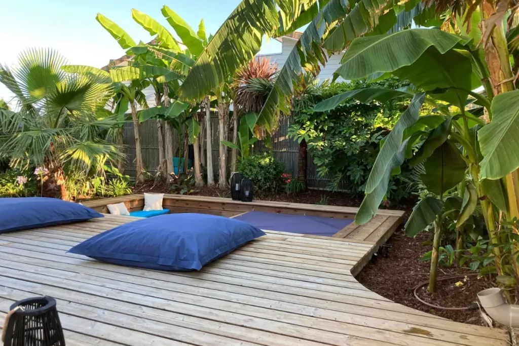 Terrase en bois avec piscine entouré de verdure à Plascassier
